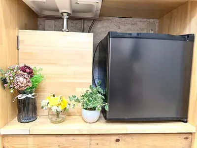 a flat screen tv sitting on a wooden shelf with flowers at Shinjuku center2/4mins from Shinjuku sta./Max4 in Tokyo