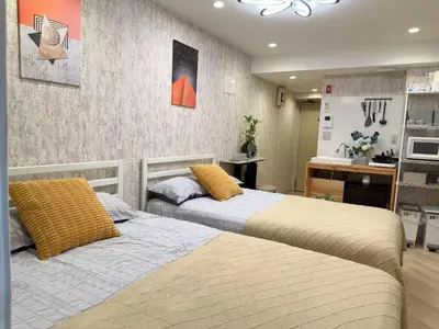 two beds sitting next to each other in a bedroom at Shinjuku center2/4mins from Shinjuku sta./Max4 in Tokyo