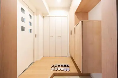 a hallway with white cabinets and a row of shoes at Generous Forest 301 in Tokyo