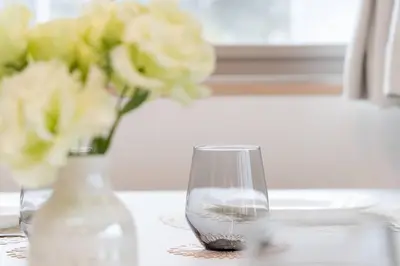 a vase and a glass with flowers on a table at Generous Forest 301 in Tokyo