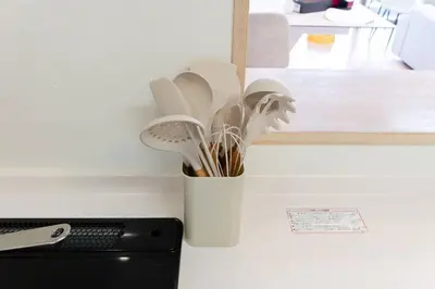 a white vase filled with utensils on a counter at Generous Forest 301 in Tokyo
