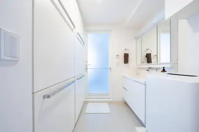 a white kitchen with a sink and a refrigerator at Generous Forest 301 in Tokyo