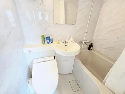 a white bathroom with a toilet and a sink at shinookubo A room in Tokyo