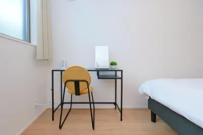 a desk with a yellow chair in a bedroom at ACOE HATSUDAI - 4BR Entire Home Upscale Area in Tokyo
