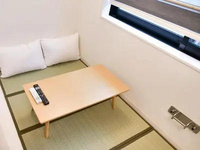 a remote control sitting on a table in a room at Okubo Shinjuku new open Capsule hotel in Tokyo