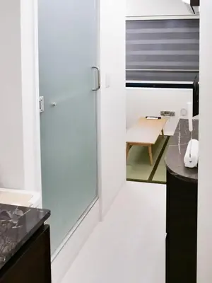 a kitchen with a glass door and a table at Okubo Shinjuku new open Capsule hotel in Tokyo