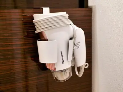 a white coffee maker hanging on a wall at Okubo Shinjuku new open Capsule hotel in Tokyo