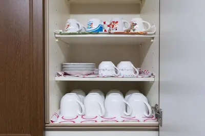 a cup and saucers and plates in a cabinet at \u677e\u5cf6\u96c5\u5c45 in Tokyo