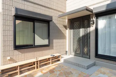 a bench on the side of a building with a window at \u677e\u5cf6\u96c5\u5c45 in Tokyo