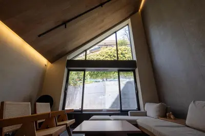a large window in a room with a couch and a table at Kakurega Tokyo villa in Tokyo