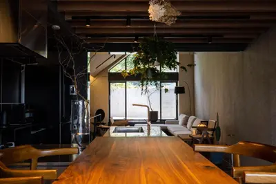a dining room with a large wooden table and chairs at Kakurega Tokyo villa in Tokyo