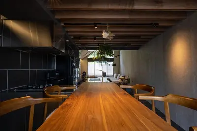 a kitchen with a long wooden table and chairs at Kakurega Tokyo villa in Tokyo