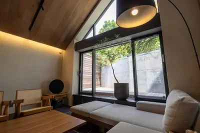 a living room with a large window and a couch at Kakurega Tokyo villa in Tokyo