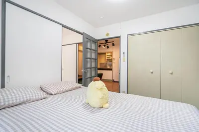 a stuffed animal sitting on a bed in a bedroom at Two-bedroom, 6-minute walk to the Yamanote Line in Tokyo