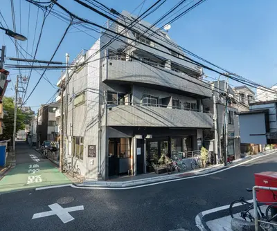 a building on the side of a street with power lines at Two-bedroom, 6-minute walk to the Yamanote Line in Tokyo