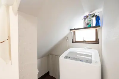a washer and dryer in a bathroom with a window at Ikebukuro East Exit Queen Bed Room, 2F in Tokyo