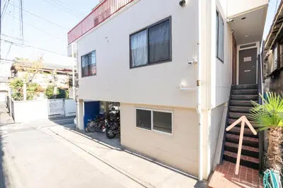 a white building with a motorcycle parked next to it at Ikebukuro East Exit Queen Bed Room, 2F in Tokyo