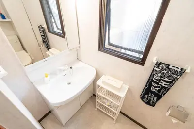a white bathroom with a sink and a mirror at Ikebukuro East Exit Queen Bed Room, 2F in Tokyo