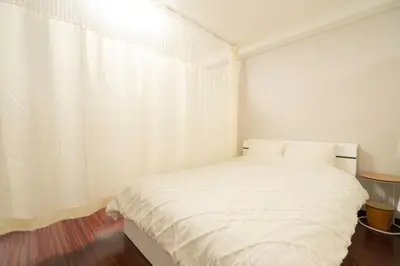 a bedroom with a white bed and a white curtain at Ikebukuro East Exit Queen Bed Room, 2F in Tokyo