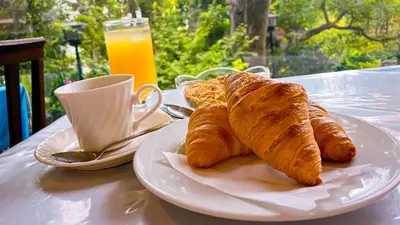 a plate of croissants and a cup of orange juice at Shinjuku Sun Park Hotel in Tokyo