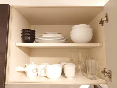 a cupboard filled with white dishes and bowls at LUCKY house53 in Tokyo