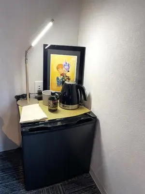 a desk with a tea kettle on top of a refrigerator at Hotel Tokyo Hub in Tokyo