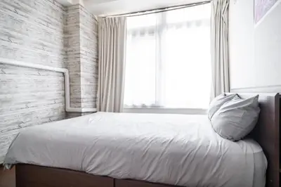 a bedroom with a large bed with a window at 3\u30d9\u30c3\u30c9\u30eb\u30fc\u30e0\u3068\u30ea\u30d3\u30f3\u30b0 4\u90e8\u5c4b\u5168\u3066\u500b\u5ba4 \u6df7\u307e\u306a\u30442\u3064\u306e\u30b7\u30e3\u30ef\u30fc\u30eb\u30fc\u30e0\u3068\u30c8\u30a4\u30ec \u6771\u65b0\u5bbf\u99c52\u52068\u540d in Tokyo