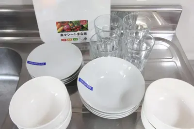 four white plates and glasses on a counter at LUANAHOTEL IN KABUKICHO in Tokyo