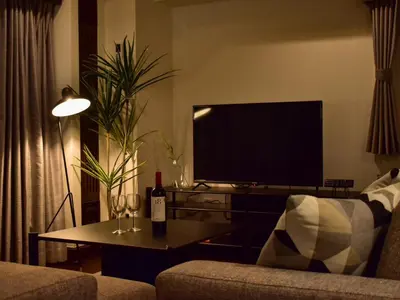 a living room with a television and a table with a bottle of wine at \u30b5\u30f3\u30e2\u30fc\u30eb\u30af\u30ec\u30b9\u30c8202 in Tokyo
