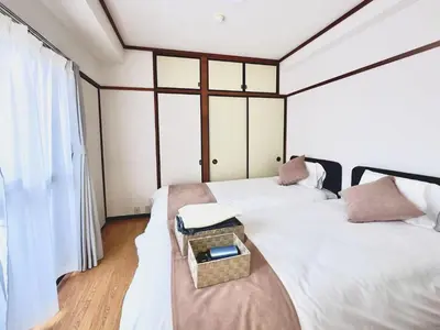 a bedroom with two beds and a table on a bench at Emoto Asakusa in Tokyo