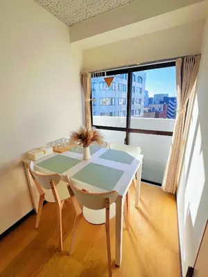 a dining room with a table and chairs and a window at Emoto Asakusa in Tokyo
