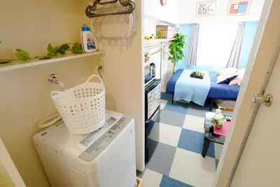 a small room with a washing machine and a bedroom at Kameari 811 Budget Stay High Floor Near Station Mall Disney Access in Tokyo