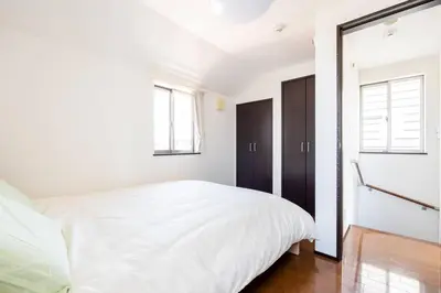 a bedroom with a white bed and two windows at FUJIMI TOWN HOUSE in Tokyo