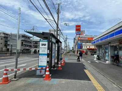 a bus stop on a street with orange and white cones at FUJIMI TOWN HOUSE in Tokyo
