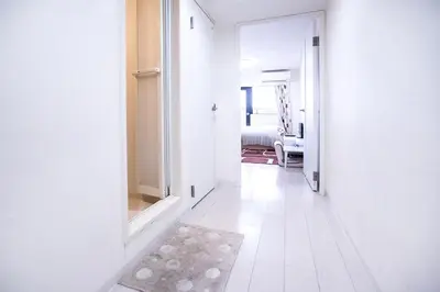 a white hallway with a door leading to a bedroom at Shinjuku Ryokan Retreat丶Local Tokyo Experience & Short Trips Hub丶walk to Higahsi Shinjuku station LoE2 in Tokyo