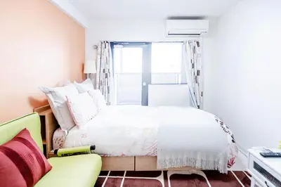 a bedroom with a bed and a yellow couch at Shinjuku Ryokan Retreat丶Local Tokyo Experience & Short Trips Hub丶walk to Higahsi Shinjuku station LoE2 in Tokyo