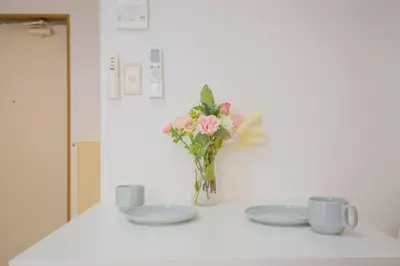a table with two plates and a vase of flowers at \u9591\u9759\u306a\u4f4f\u5b85\u8857_\u6696\u304b\u304f\u5c45\u5fc3\u5730\u306e\u826f\u3044\u30c7\u30b6\u30a4\u30f3 YoY-6 in Tokyo