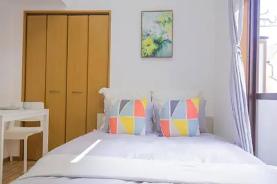 a bedroom with a bed with a wooden cabinet and a table at \u9591\u9759\u306a\u4f4f\u5b85\u8857_\u6696\u304b\u304f\u5c45\u5fc3\u5730\u306e\u826f\u3044\u30c7\u30b6\u30a4\u30f3 YoY-6 in Tokyo