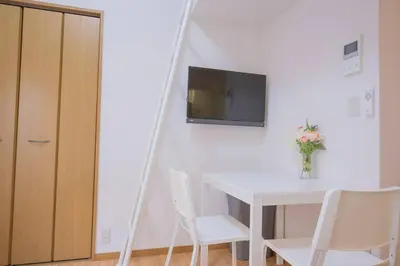 a white table and chairs with a television on a wall at \u9591\u9759\u306a\u4f4f\u5b85\u8857_\u6696\u304b\u304f\u5c45\u5fc3\u5730\u306e\u826f\u3044\u30c7\u30b6\u30a4\u30f3 YoE-6 in Tokyo