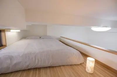 a bedroom with a large white bed and a lamp at \u9591\u9759\u306a\u4f4f\u5b85\u8857_\u6696\u304b\u304f\u5c45\u5fc3\u5730\u306e\u826f\u3044\u30c7\u30b6\u30a4\u30f3 EoS-J in Tokyo