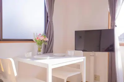 a white table with a vase of flowers and a tv at \u9591\u9759\u306a\u4f4f\u5b85\u8857_\u6696\u304b\u304f\u5c45\u5fc3\u5730\u306e\u826f\u3044\u30c7\u30b6\u30a4\u30f3 SoW-2 in Tokyo