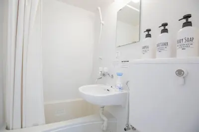 a white bathroom with a sink and a mirror at \u9591\u9759\u306a\u4f4f\u5b85\u8857_\u6696\u304b\u304f\u5c45\u5fc3\u5730\u306e\u826f\u3044\u30c7\u30b6\u30a4\u30f3 SoW-2 in Tokyo