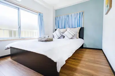 a large bed in a room with a large window at 10min walk to Shinjuku YoY5 in Tokyo
