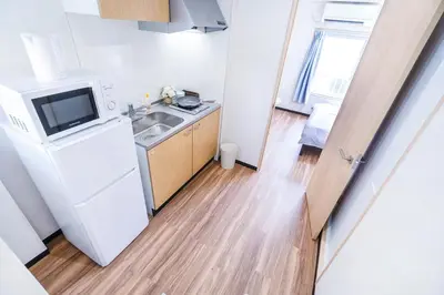 a small kitchen with a sink and a refrigerator at 10min walk to Shinjuku YoY5 in Tokyo