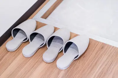 a row of gray and black suede rain slippers at 10min walk to Shinjuku YoY5 in Tokyo