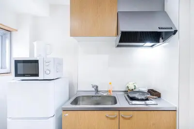 a small kitchen with a sink and a microwave at 10min walk to Shinjuku YoY5 in Tokyo