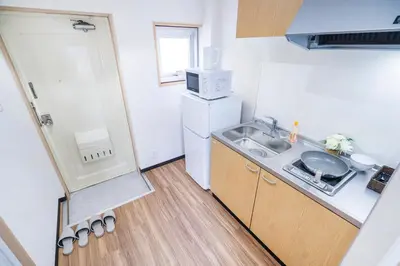 a small kitchen with a sink and a refrigerator at 10min walk to Shinjuku YoY5 in Tokyo