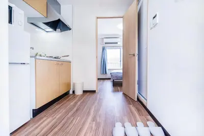 a hallway with a kitchen and a door to a room at 10min walk to Shinjuku YoY5 in Tokyo