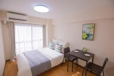 a bedroom with a bed and a table and a window at walk to Higahsi Shinjuku sta. SYW in Tokyo
