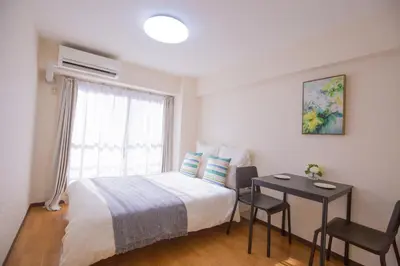 a bedroom with a bed and a table and a window at walk to Higahsi Shinjuku sta. SYW in Tokyo